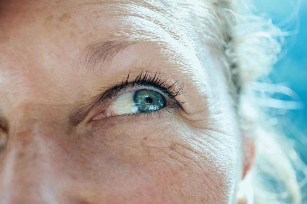 Close up of mature woman's face as she looks up and smiles.