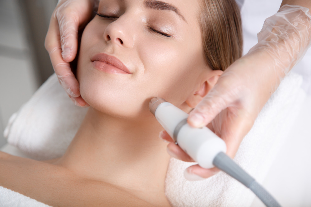 Woman smiling while getting laser skin treatment